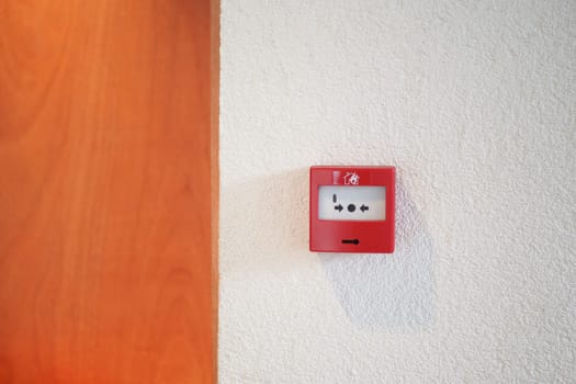 Red fire alarm button on wall