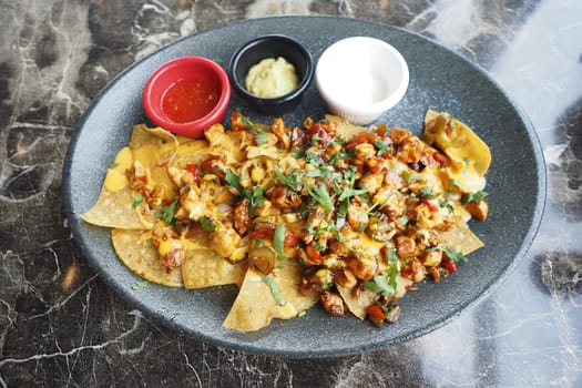 Corn chips nachos with fried meat on table