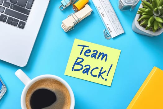 A Desk setup with laptop, coffee, and stationery, welcoming team back