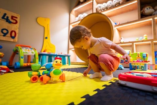 Active child playing in a vibrant and interactive play area filled with toys, games, and activities for development and fun
