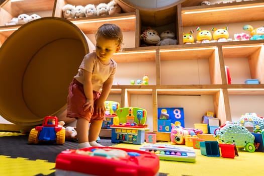 Curious toddler exploring a colorful and interactive playroom filled with toys and games for fun, learning, and creativity