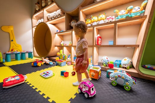 Toddler exploring colorful toys and games in a modern indoor playroom