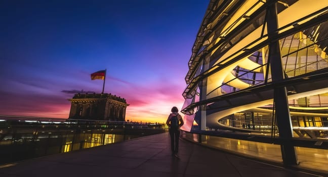 Berlin, Germany - 19 September 2019: Lonely tourist walking along evening Reichstag