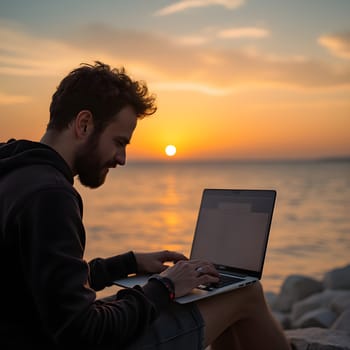 A digital nomad working on a laptop by the beach during sunset, representing freedom, remote work, and modern lifestyles.