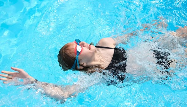 Little Girl Gracefully Backstroking In Hotel Summer Pool