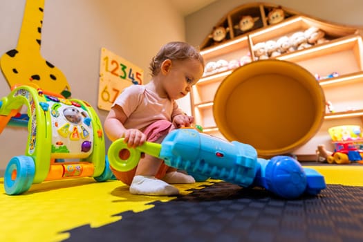 Child cleaning with a toy vacuum cleaner in a vibrant play area designed for imagination and motor skill development