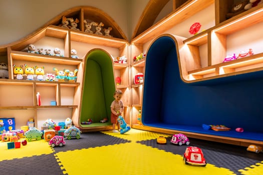 Toddler exploring toys and games in a vibrant indoor play area designed for fun and creativity
