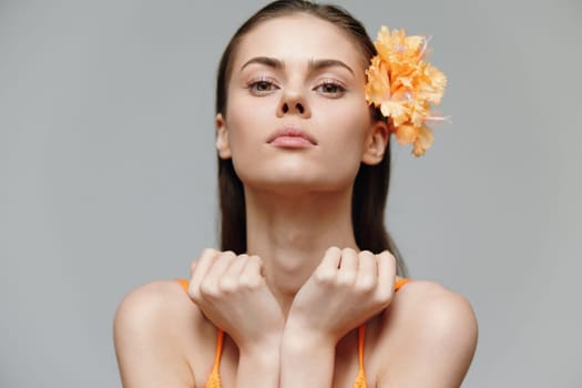 A stunning model wearing a vibrant orange outfit, exuding confidence with delicate, thoughtful emotions, suitable for fashion, beauty, and editorial themes.