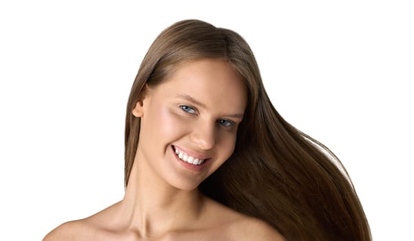 Studio portrait of smiling woman with perfect teeth and healthy long brown hair flowing in wind on white background.