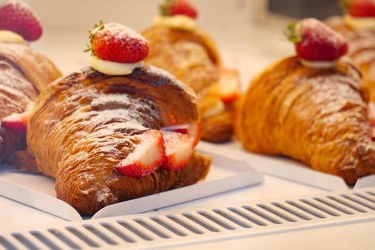 Enjoy fresh, buttery croissants topped with strawberries and cream for a perfect breakfast