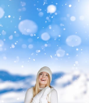 Blonde woman wearing warm mittens, knitted beanie hat and jumper, winter snow nature background with copyspace fashion and lifestyle idea
