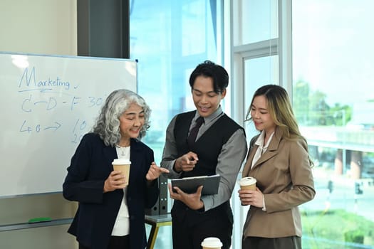 Professional businesspeople analyzing financial data on clipboard and planning work at meeting.