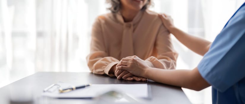 Female nurse hold her senior patient hand. Giving Support. Doctor help patient with disease. Female carer holding hands of senior woman.