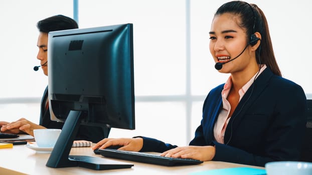 Business people wearing headset working in office to support remote customer or colleague. Call center, telemarketing, customer support agent provide service on telephone video conference call. Jivy