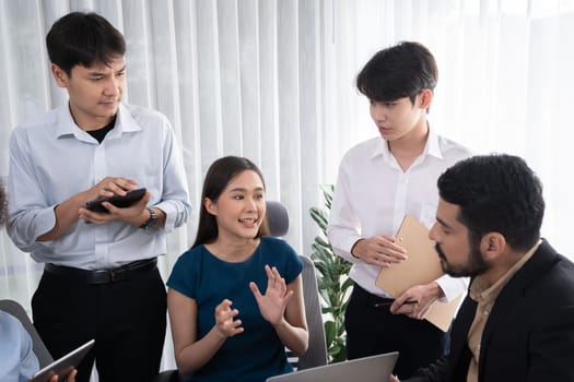 Happy diverse business people work together, discussing in corporate office. Professional and diversity teamwork discuss business plan on desk with laptop. Modern multicultural office worker. Concord