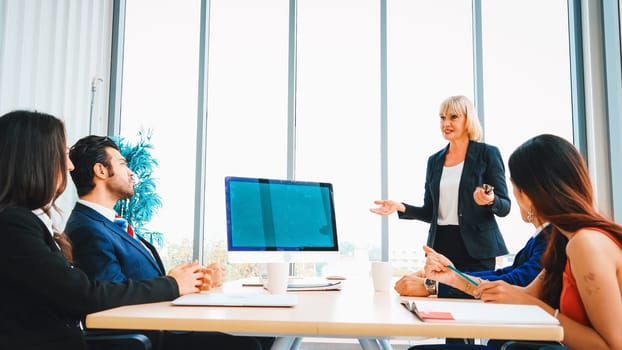 Business people in the conference room with green screen chroma key TV or computer on the office table. Diverse group of businessman and businesswoman in meeting on video conference call . Jivy