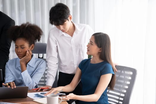 Happy diverse business people work together, discussing in corporate office. Professional and diversity teamwork discuss business plan on desk with laptop. Modern multicultural office worker. Concord