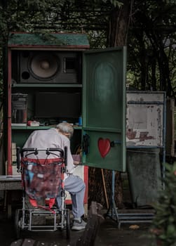 Bangkok, Thailand - 22 Sep, 2023 - The old grey-haired man is controlling and playing the musical instrument in the park for entertaining people who come to relax and workout. Selective focus.
