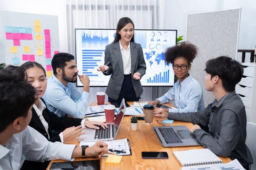 Young asian businesswoman presenting data analysis dashboard on TV screen in modern meeting. Business presentation with group of business people in conference room. Concord