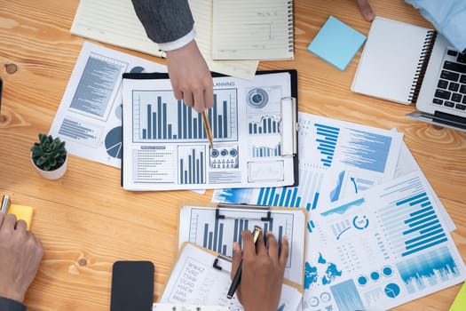 Flat top view workspace wooden table with analyst team use BI dashboard papers data for planning business strategy. Businesspeople utilize data analysis by FIntech for marketing indication. Concord