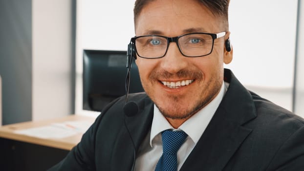 Business people wearing headset working in office to support remote customer or colleague. Call center, telemarketing, customer support agent provide service on telephone video conference call. Jivy