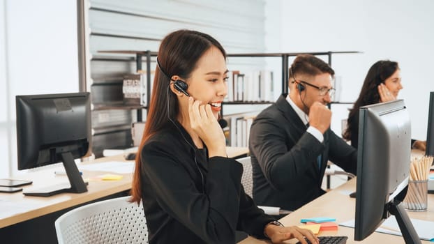 Business people wearing headset working in office to support remote customer or colleague. Call center, telemarketing, customer support agent provide service on telephone video conference call. Jivy