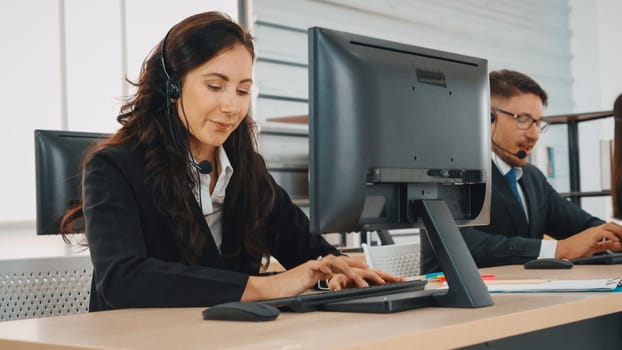 Business people wearing headset working in office to support remote customer or colleague. Call center, telemarketing, customer support agent provide service on telephone video conference call. Jivy