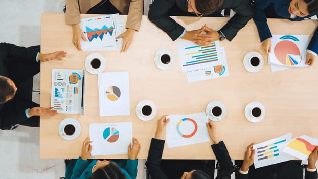 Business people group meeting shot from top view in office . Profession businesswomen, businessmen and office workers working in team conference with project planning document on meeting table . Jivy