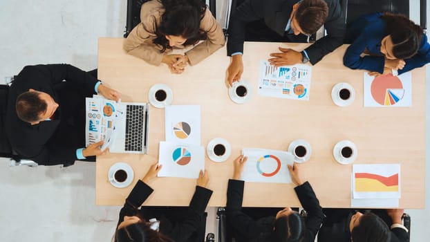 Business people group meeting shot from top view in office . Profession businesswomen, businessmen and office workers working in team conference with project planning document on meeting table . Jivy