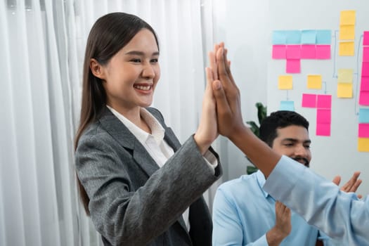 Diverse business team celebrate successful meeting with high-fives and expressions of happiness in corporate office meeting represent unity success and professional integrity. Concord