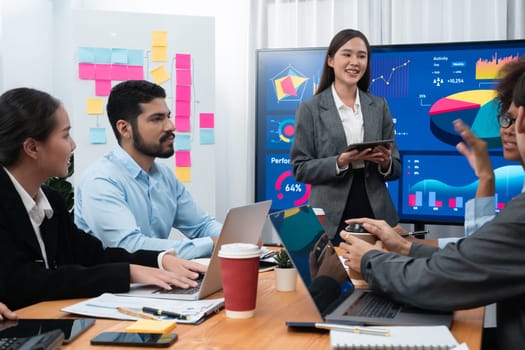 Young asian businesswoman presenting data analysis dashboard on TV screen in modern meeting. Business presentation with group of business people in conference room. Concord