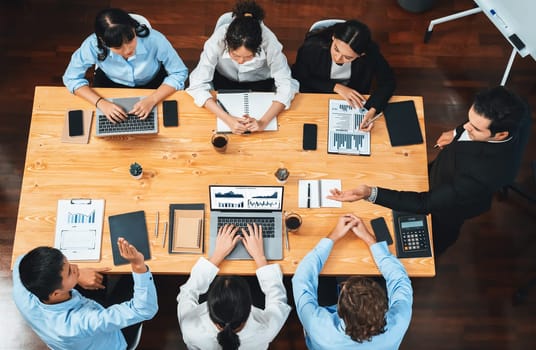 Panorama top view diverse group of business analyst team analyzing financial data report paper on meeting table. Chart and graph dashboard by business intelligence analysis. Meticulous