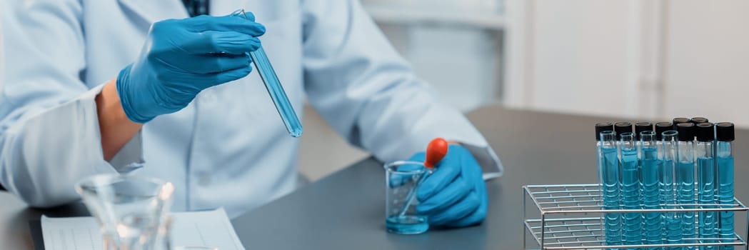 Scientist conduct chemical experiment in medical laboratory, carefully drop precise amount of liquid from pipette into test tube for vaccine drug or antibiotic development. Neoteric