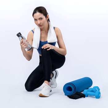 Athletic and sporty asian woman resting and drink water after intensive cardio workout training. Healthy exercising and fit body care lifestyle pursuit in studio shot isolated background. Vigorous