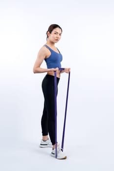 Vigorous energetic woman in sportswear portrait stretching resistance sport band. Young athletic asian woman strength and endurance training session workout routine concept on isolated background.