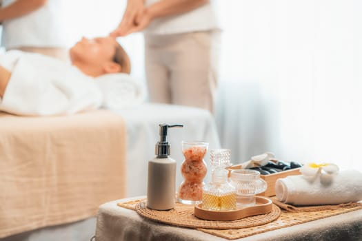 Aromatherapy massage on daylight ambiance or spa salon composition setup with focus decor and spa accessories on blur woman enjoying blissful aroma spa massage in resort or hotel background. Quiescent