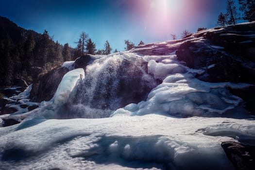 A waterfall in the middle of a snowy forest