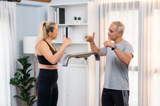 Athletic and sporty senior couple portrait in sportswear with successful or celebrating after overcome struggle posture as home exercise concept with healthy fit body lifestyle after retirement. Clout