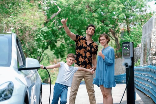 Family road trip vacation with electric vehicle, lovely family recharge EV car with green and clean energy. Natural and eco friendly car travel for sustainable environment. Perpetual