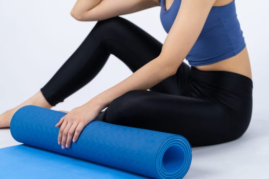 Young attractive asian woman portrait in sportswear with exercising mat. Healthy exercise and workout routine lifestyle concept. Studio shot isolated background. Vigorous