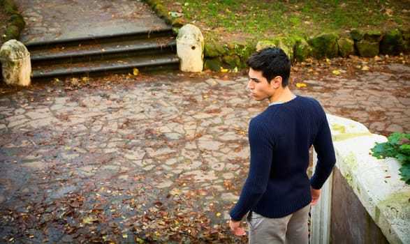 A man standing in front of a stone path. Photo of a man standing in front of a stone path