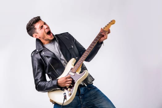 A man in a leather jacket playing a guitar