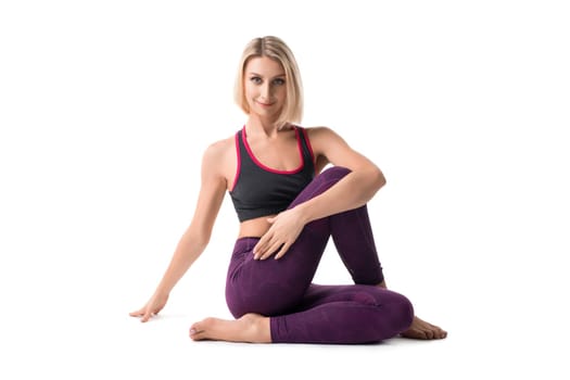 Smiling pretty blonde woman in sportswear posing and looking at camera isolated on white background