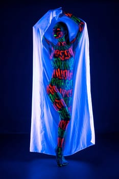 Girl with beautiful UV bodyart holding white cloth full-length view