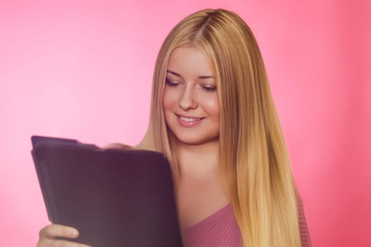 Woman, pink background and tablet, creativity and focus on ideas. Blonde beautiful woman, elegance and inspiration, working on designs and digital projects with style concept