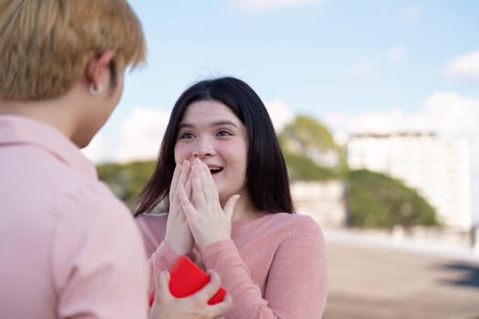 A couple shares an emotional Valentine's moment celebrating love in a beautiful outdoor environment.