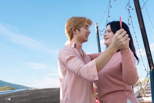 A couple joyfully celebrates their love under a clear sky creating lasting memories during Valentine's Day.