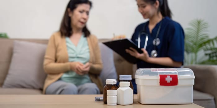 A caregiver provides medical guidance to an elderly patient fostering a warm and compassionate home environment.