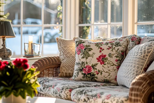 Colorful pillows on sofa against glass wall of window in a winter garden or conservatory. Interior textile concept. High quality photo