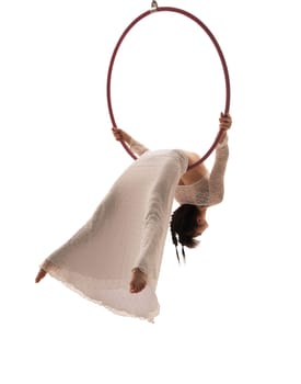 Woman in long white dress hanging gracefully on a ring isolated shot
